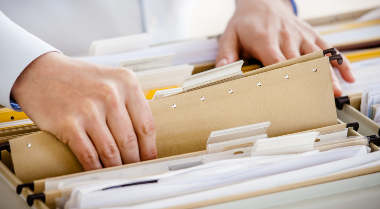 Administrative assistant organizing a filing cabinet.