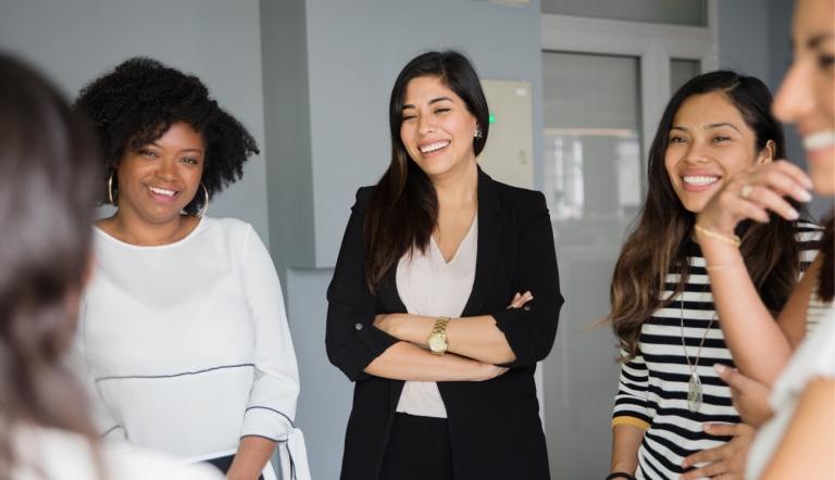A group of women talking in an office setting.