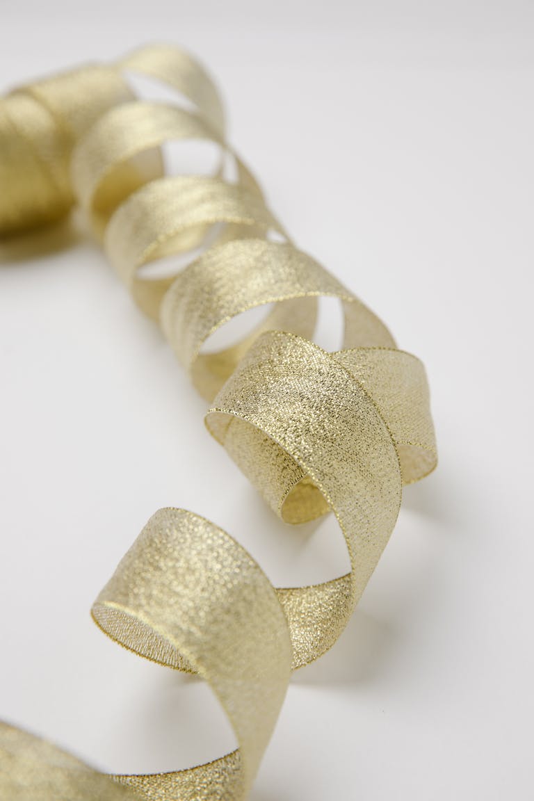 Shiny golden twisted ribbon on table