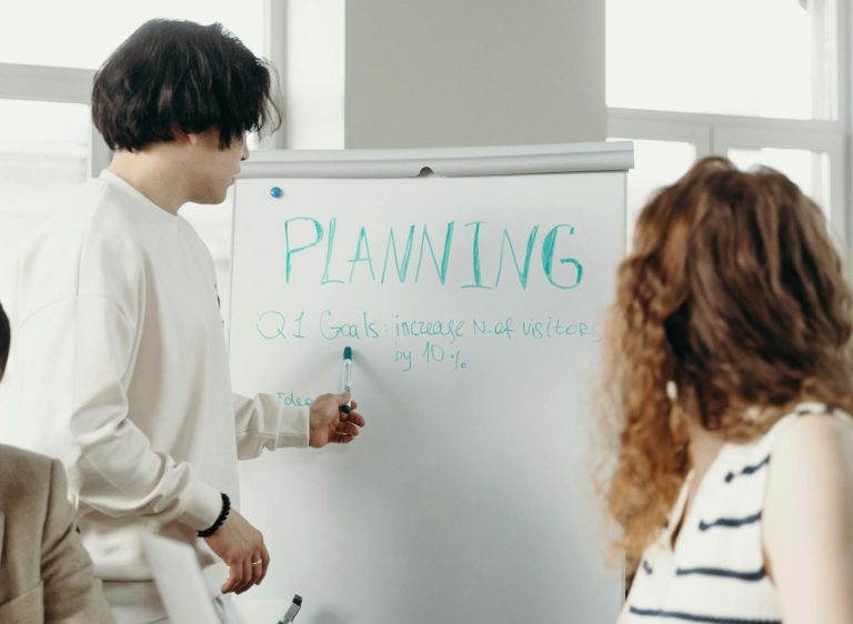 Support staff brainstorming and goal-setting during a business meeting in a modern office setting.