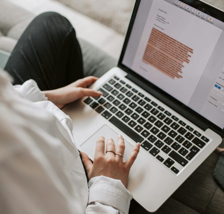 Woman typing out a cover letter on a laptop indoors, curious if cover letters are still relevant.