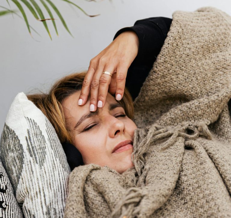 A woman laying on couch anxious and overwhelmed. Fight the Sunday Scaries.